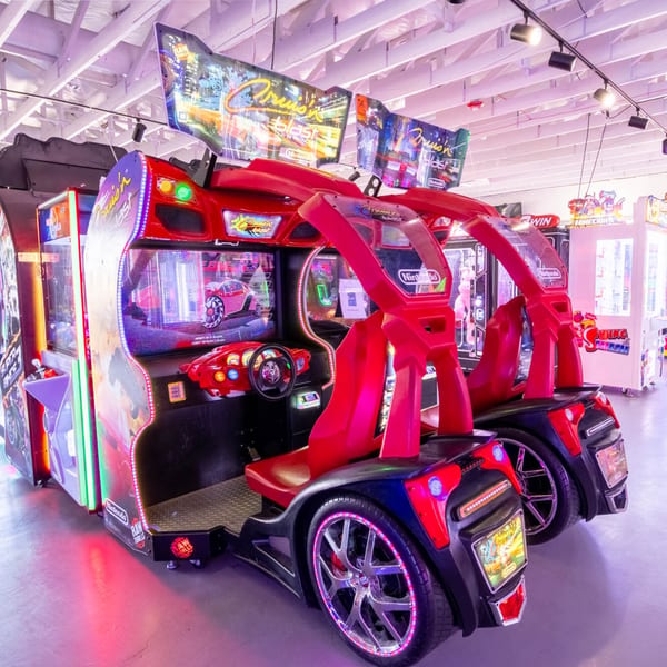Two red Cruis'n Blast arcade racing games with glowing lights inside the IWingz restaurant.